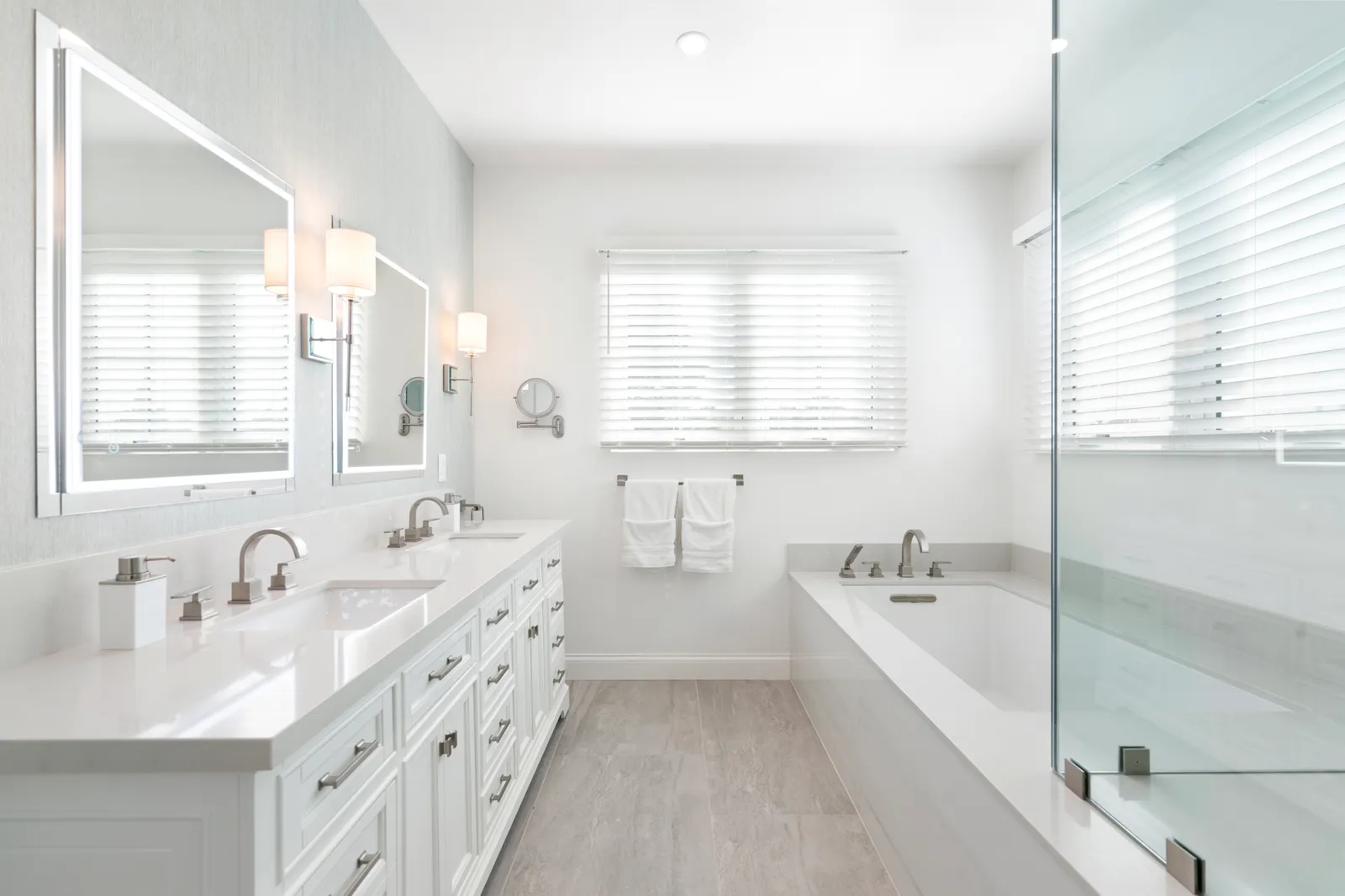 Bright white primary bathroom with a double vanity.