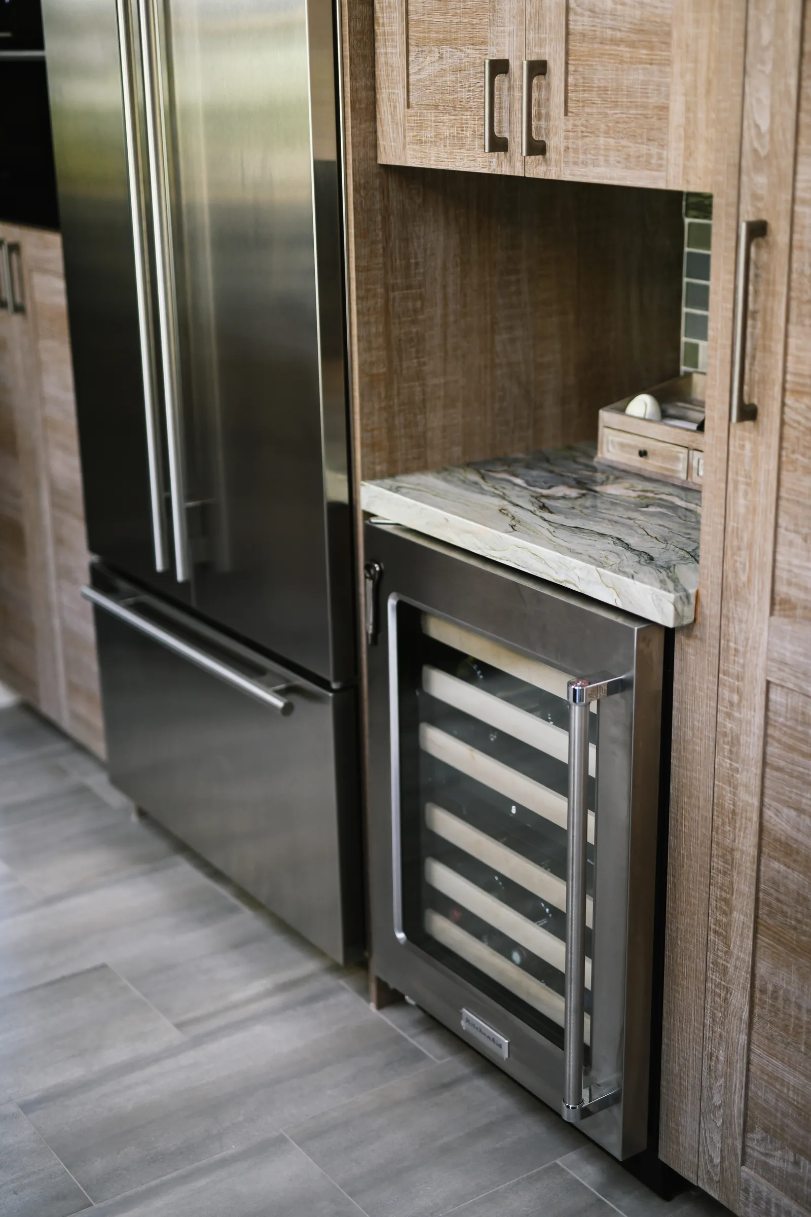 Sleek contemporary kitchen with white cabinets, stainless appliances, and large windows.