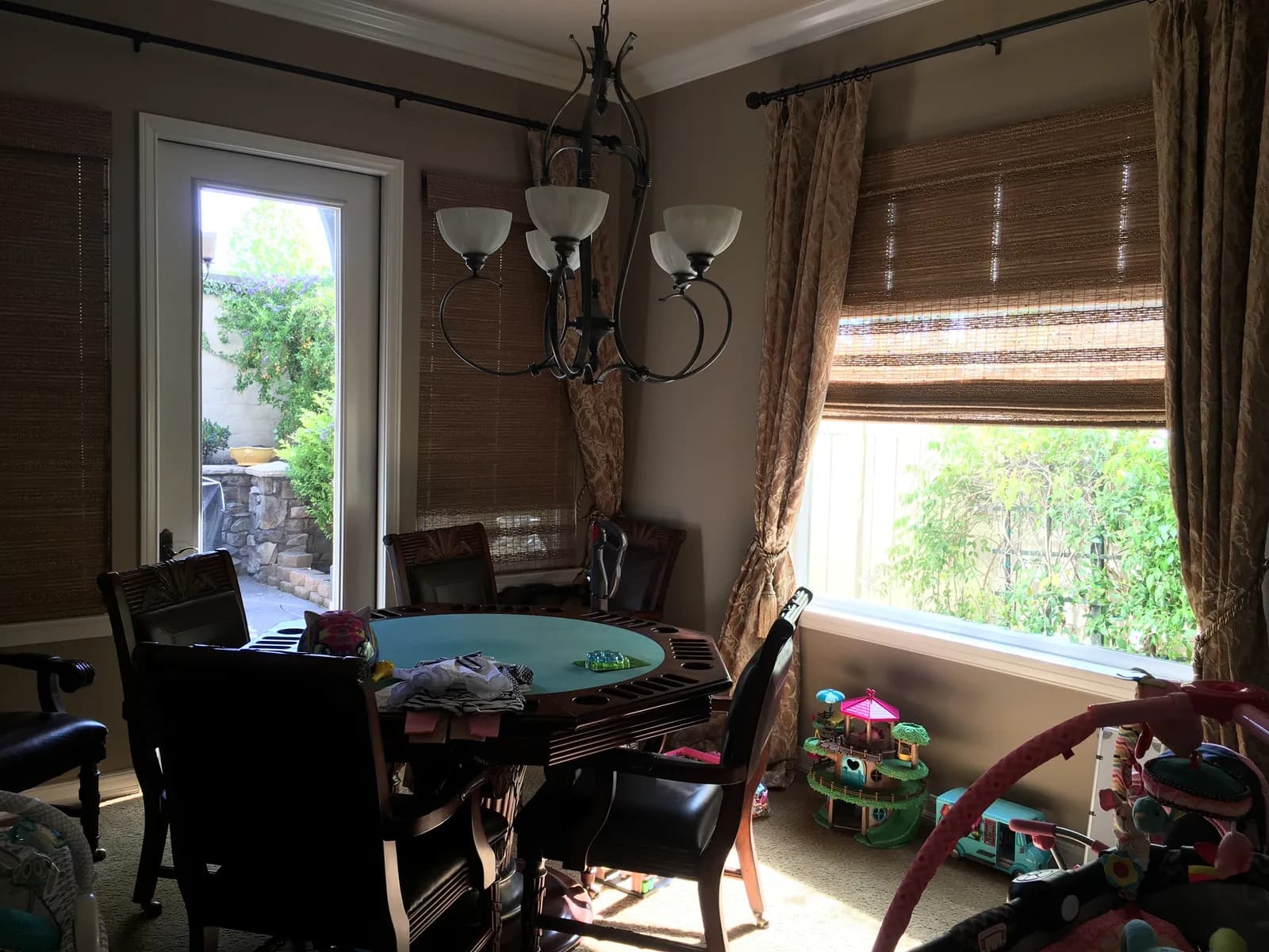 Dining room with dark walls and woven shades.