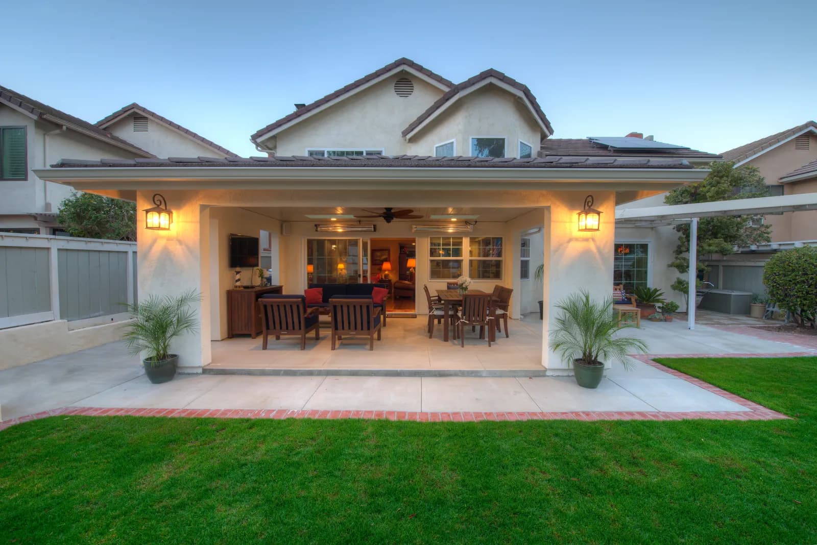 Large covered patio with modern seating and view to pool and distant landscape.