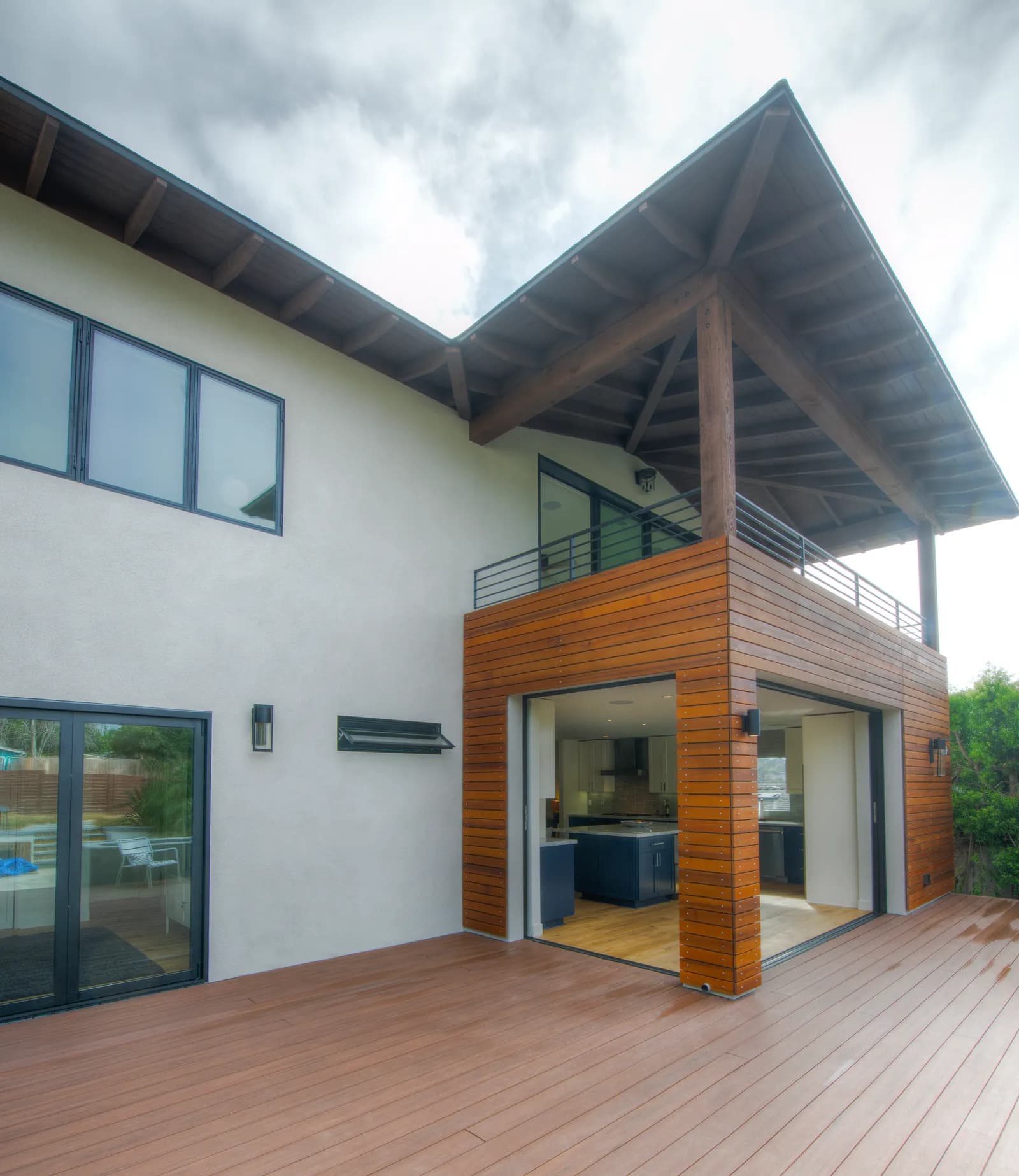 Contemporary home featuring wood siding addition and extended deck area.